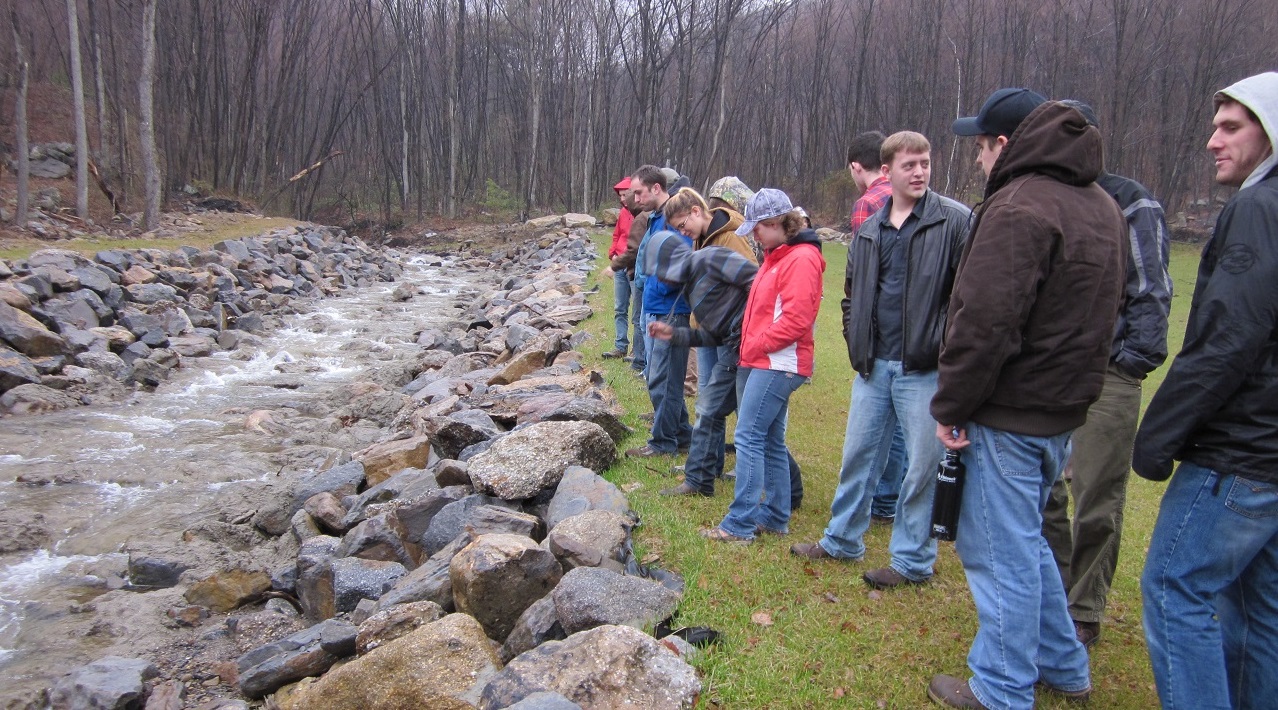 Group of students lined up and facing a river