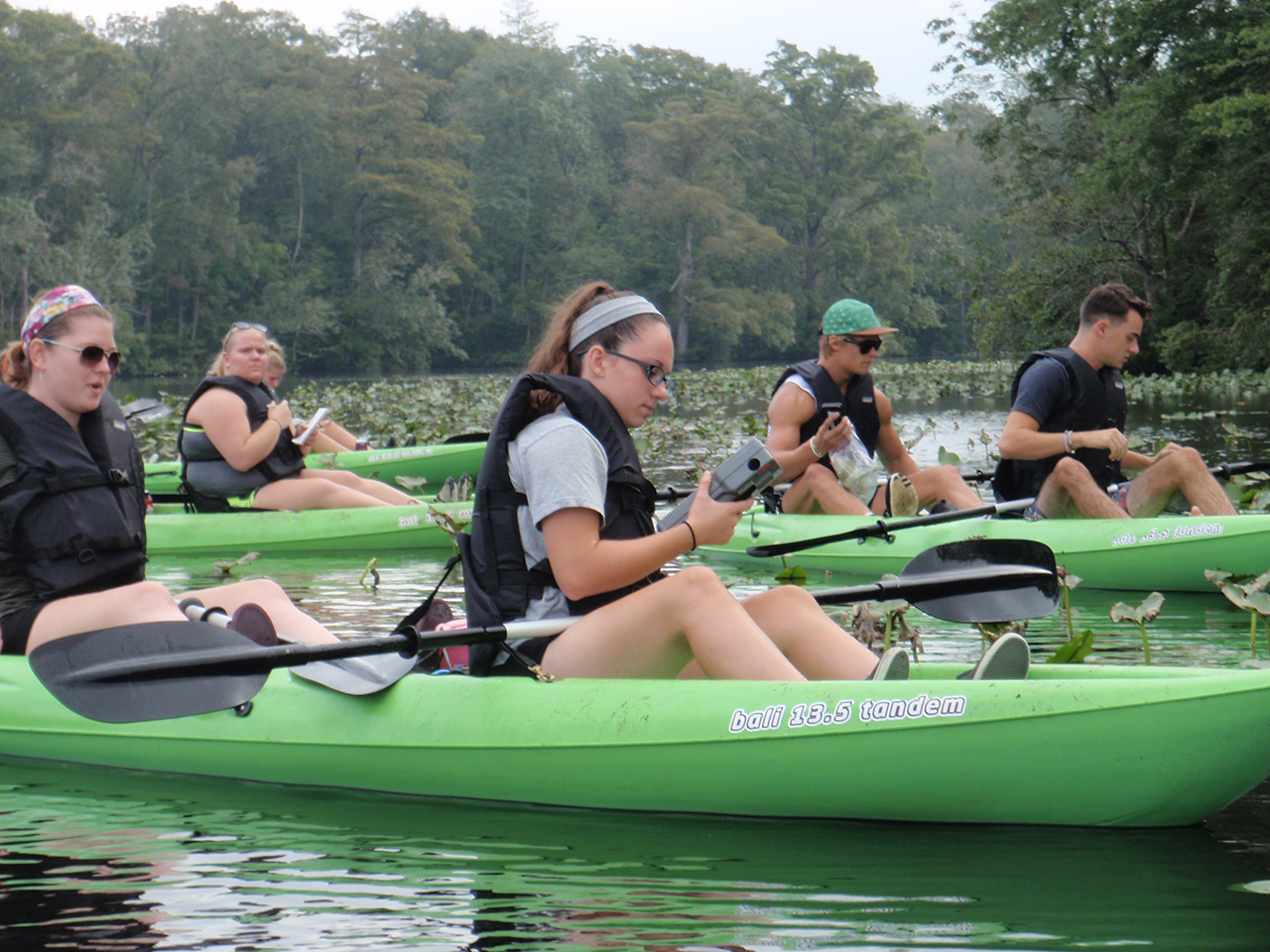 Students on kayaks with equipment