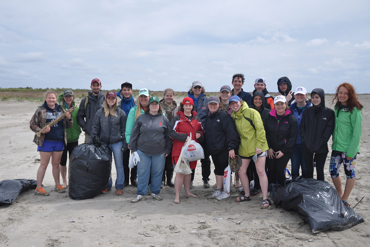 marine biology students with bags of trash at the beach
