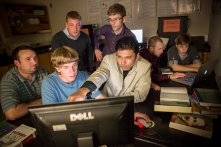 Groups of students and a professor looking at data on computer screens