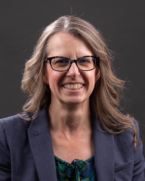 Dr. Michelle Kiec headshot in front of a dark gray background 