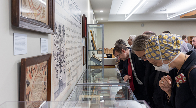 Visitors looking at collection in glass case.
