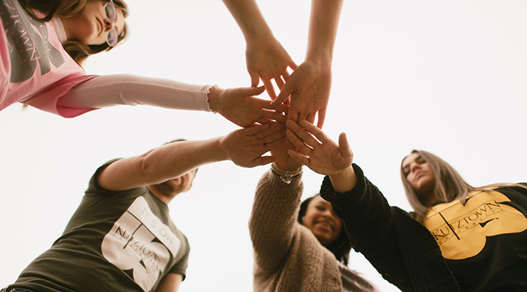 Students putting hands together
