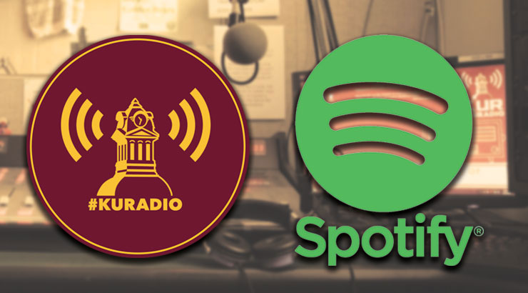 Image of sound studio desk is background. To the left is a maroon circle outlined in gold. In the center of the circle is a gold image of the clock tower with sound symbols on each side. Below the clock tower is #KURADIO. To the right of the maroon circle, is the green Spotify Icon with the word Spotify below it in green type. 