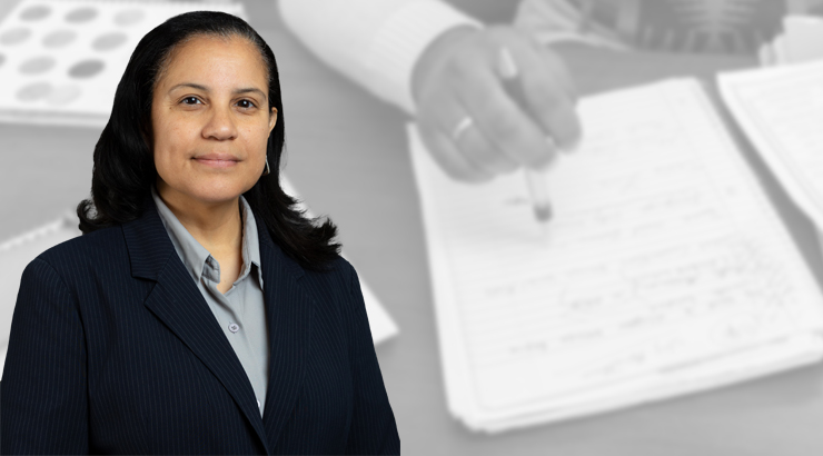 Photo of Nieves with papers on table in background