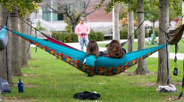 Photo of a group of students in hammocks on Rohrbach Library lawn.