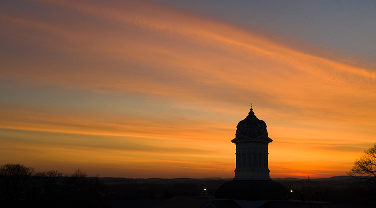A silhouette of Old Main clock tower at sunset.