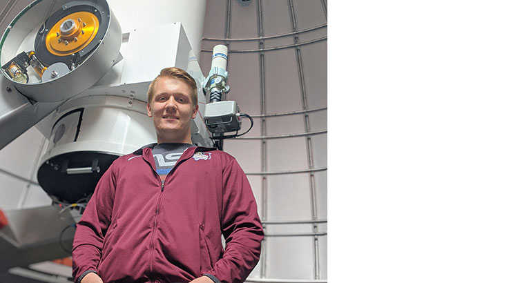 Kutztown University astronomy student, Tyler Fenske, stands in front of the C.R. Chambliss Astronomical Observatory telescope. 