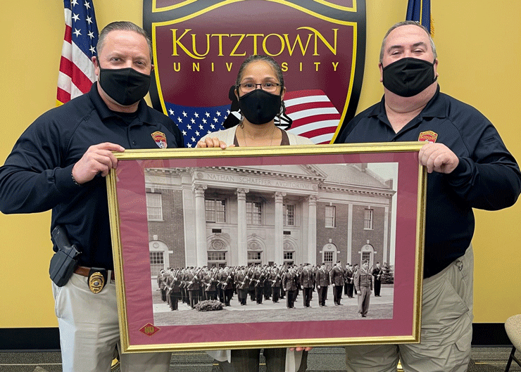 Chief of Police John Dillon (right) and Deputy chief of Police David Drezek (left) present a framed photo of Kutztown State Teachers College WWII Army Air Cadets to Tania Brown (center) in the Office of Military and Veterans Services.
