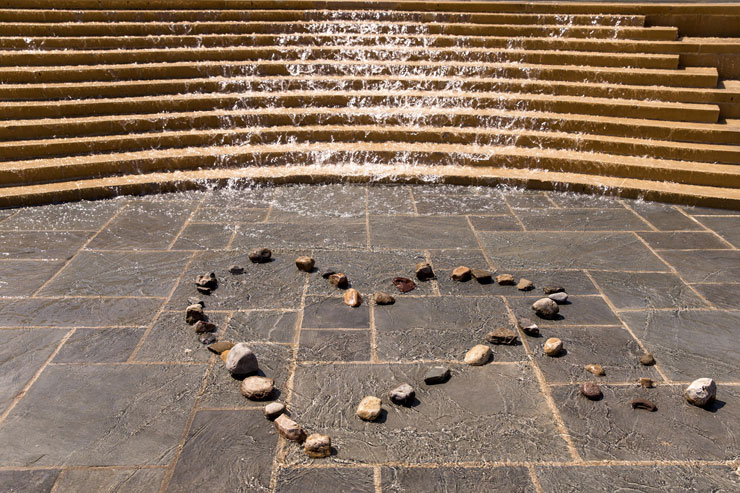 Alumni Plaza fountain flows down to the base of the water fall staircase where the shape of a heart is made in river stone. 