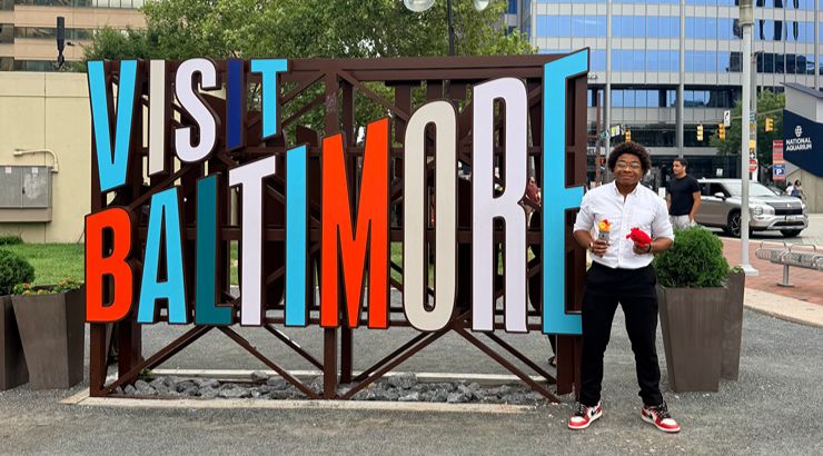 Dent next to "Visit Baltimore" sign