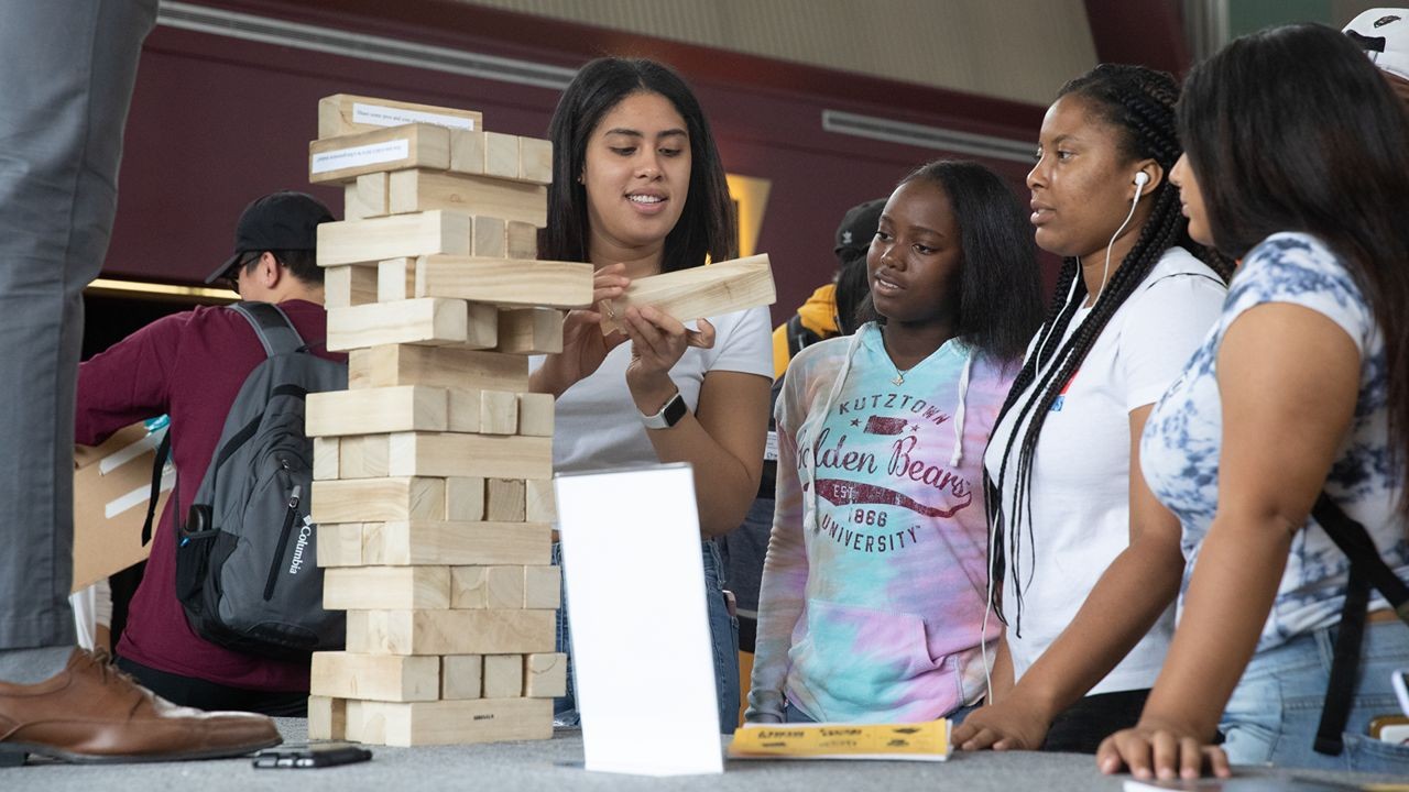 Four female students building jigsaw puzzles at first gen fest.