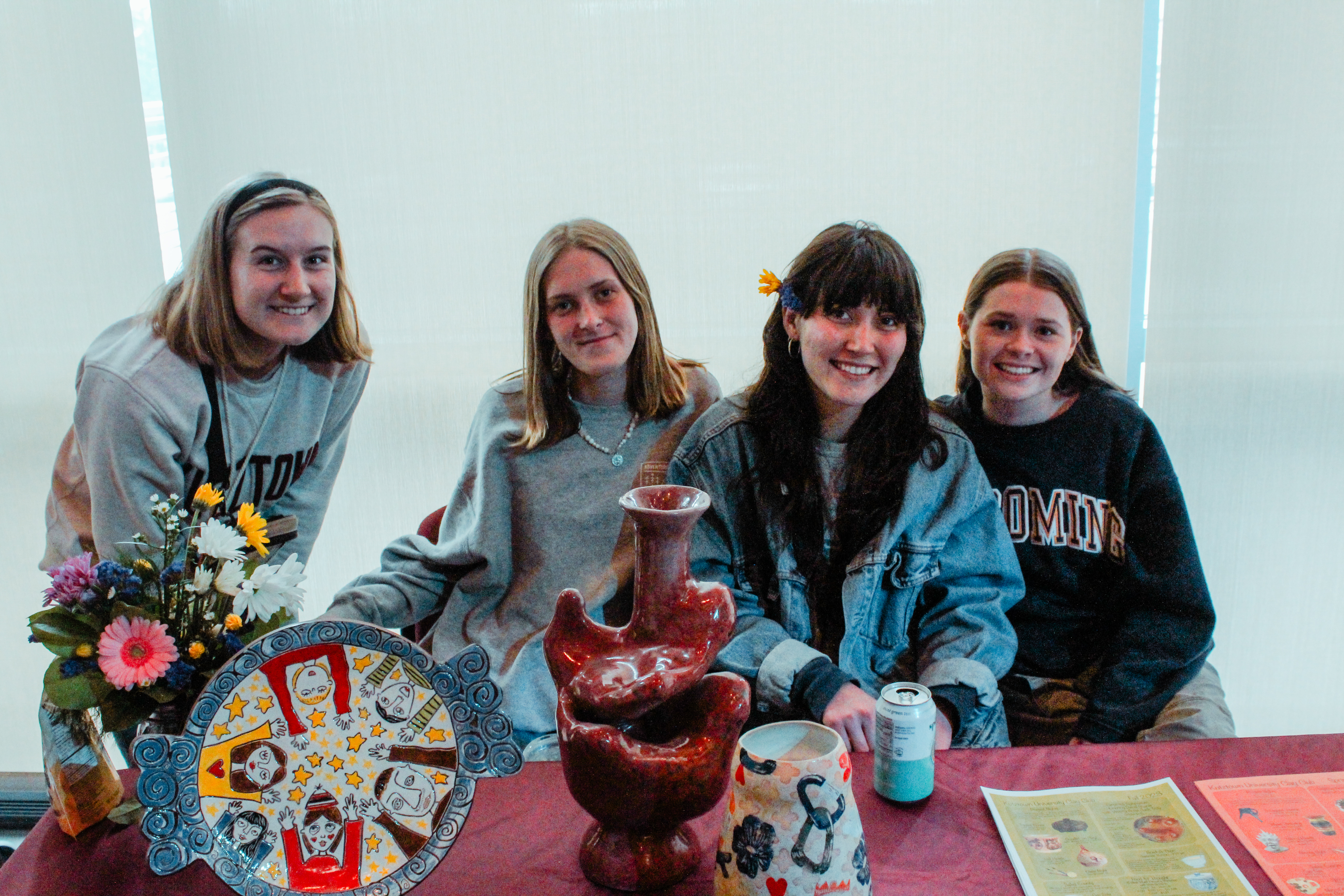 Students sitting at Table with pottery
