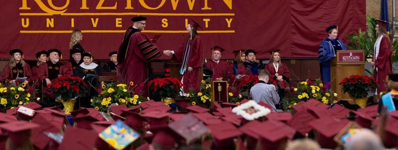 Graduates cross the stage to receive diplomas.
