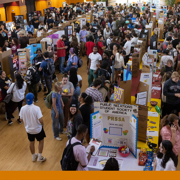 An arial view of the involvement fair with people looking at displays and conversing about clubs and organizations on campus to be involved in.
