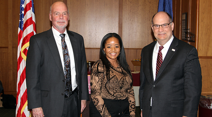 Jim Ludlow, Khadijah McPherson and Dr. Hawkinson smiling together in an Old Main boardroom 