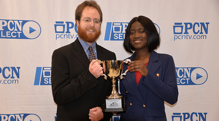 Shantal Ewell (right) and Kevin Smyth (left) holding their first place Business Plan Competition trophy and smiling