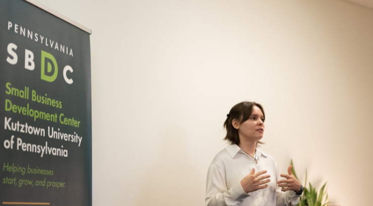 Maddison Stanley talking in front of a SBDC sign