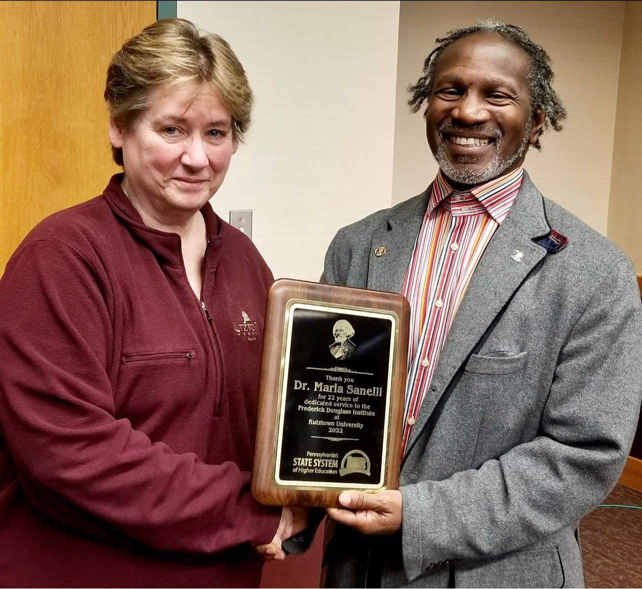 Maria Sanelli and Joseph Croskey smiling and holding the PASSHE Frederick Douglass Institute Director plaque 