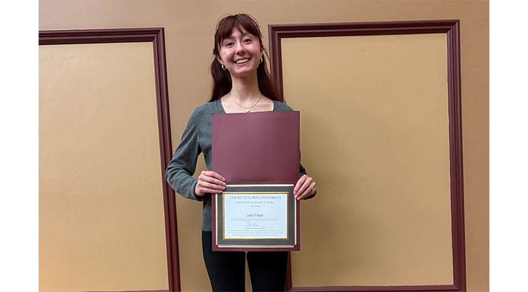 Student holding award