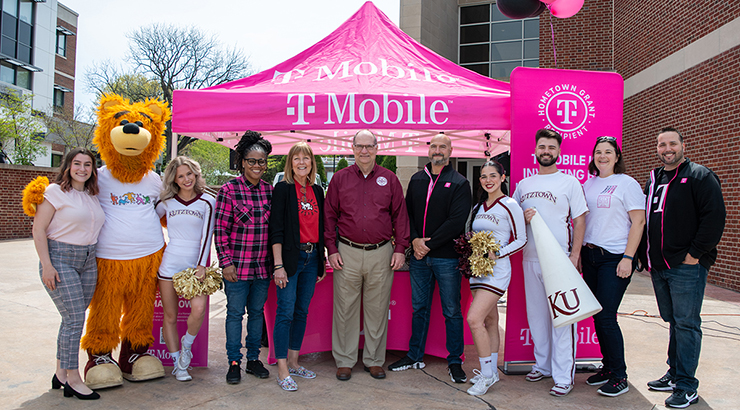 President Hawkins with faculty, Avalanche, the mascot, and students in front of T-Mobile tent