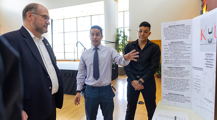 Students giving presentation to President Dr. Kenneth Hawkinson