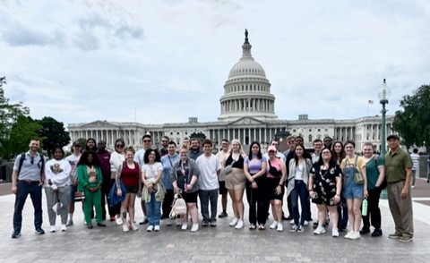 Kutztown students stand in front of the capitol building in D.C., white building with dome, blue skies behind it