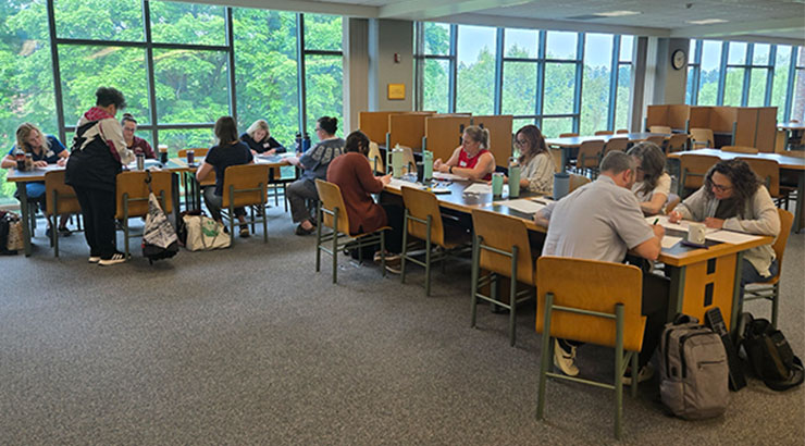 faculty sitting at tables writing