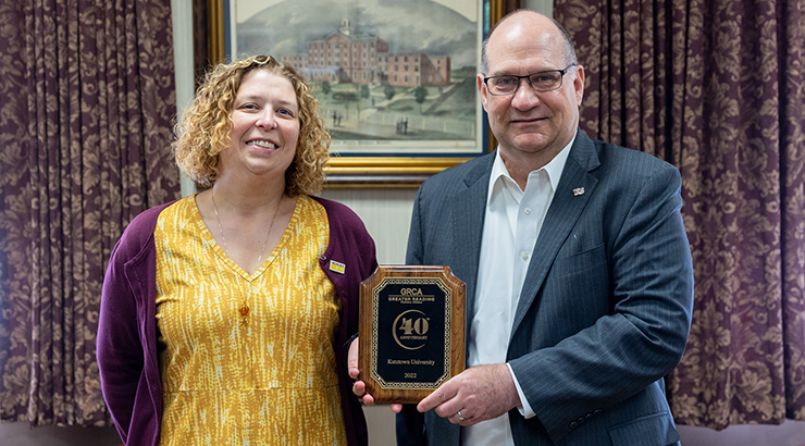 President Hawkinson and Jennifer Weidman, director of Human Resources, standing with a plaque to commemorate 40 years as a member of the Greater Reading Chamber Alliance.