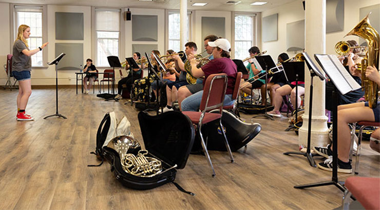 student leading musicians