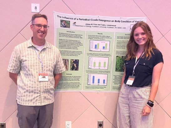 Student and professor standing next to poster