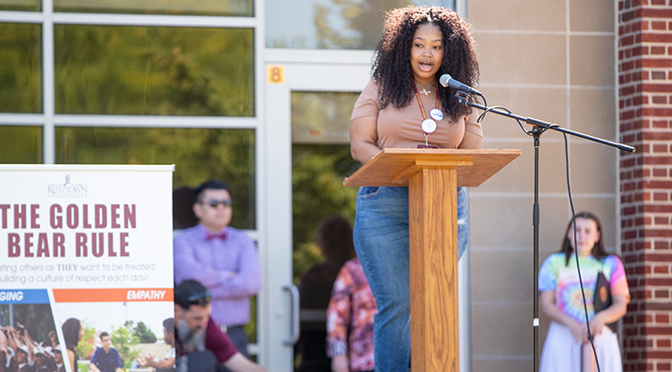 African American student speaking at podium