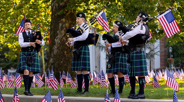 Bagpipe players in front of 9/11 flag display