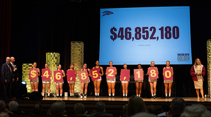 Students holding up board that spell out $46.852,180.