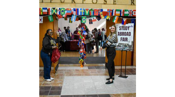 students standing in front of international flags