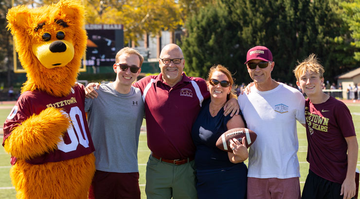 Members of the Van Brunt family post with President Cavalier and Avalanche the Golden Bear after David made a 25-yard field goal to win Evan a free semester of tuition.