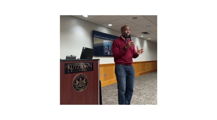 Dr. Dewsbury holding microphone