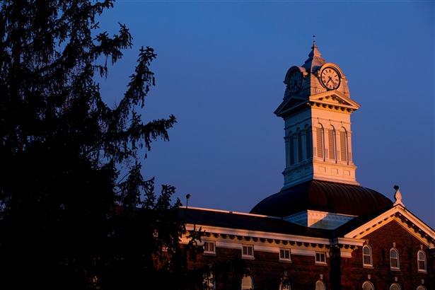 Evergreen tree on the left Old Main Clock Tower on the right