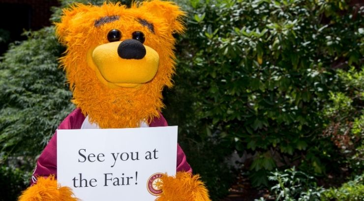 Avalanche mascot holding paper that reads, "See you at the fair!"