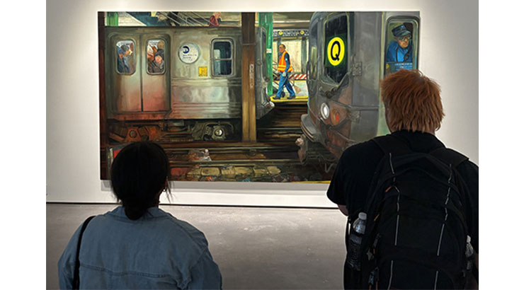 two students looking at a painting