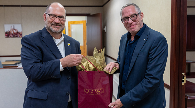 (left to right) President Hawkinson holding a gift with Dr. James McKenzie