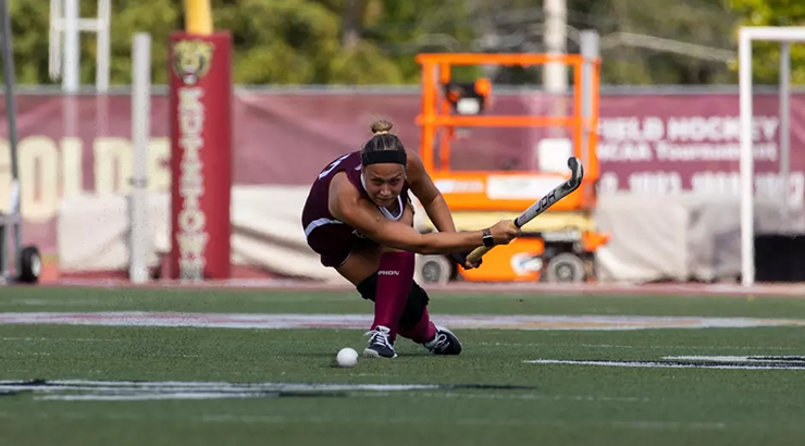 Field hockey player hitting ball