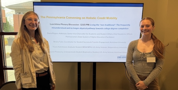 a student and a staff members standing in front of screen