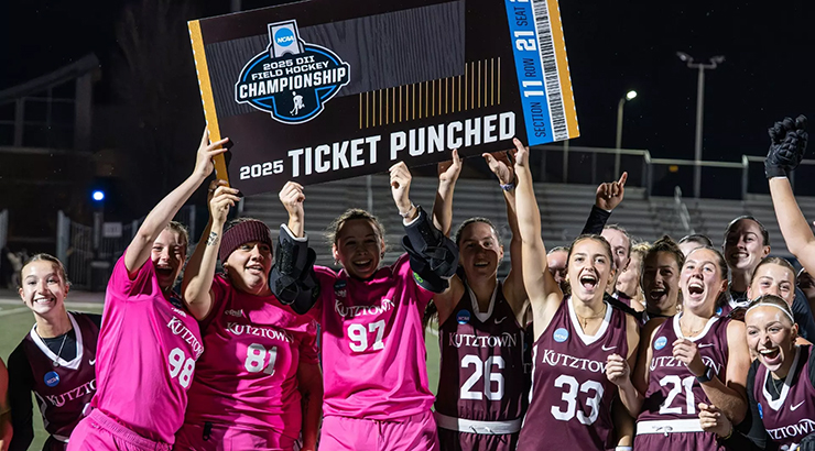 Team holding "Ticket Punched" board on field