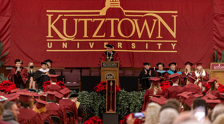 Photo of President Hawkinson at the lecturn on the stage at commencement.