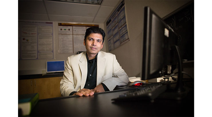 Photo of Dr. Kunal Das sitting in front of a computer