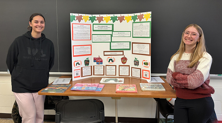 Students standing next to poster