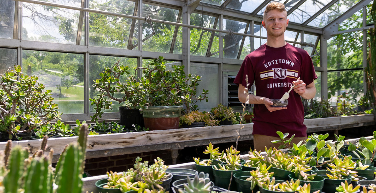 Environmental science major Patrick working on an experiement in the greenhouse.