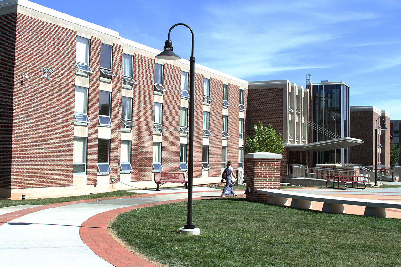 Side view of the Berks Hall entrance with a students walking by in the foreground 