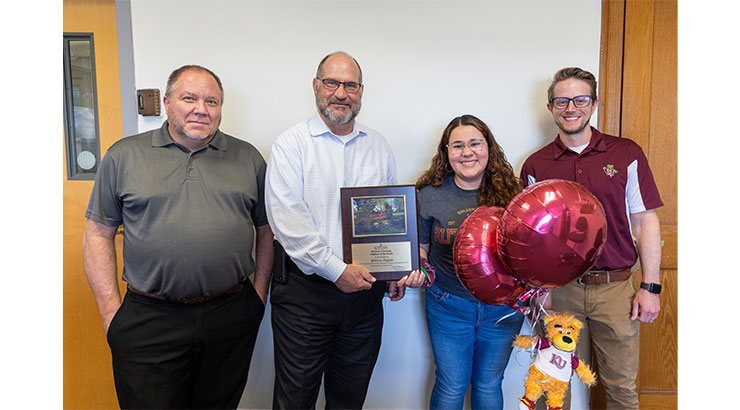 Pagan accepting award plaque and balloons from President. Left to Right: Troy Vingom, President Hawkinson, Yelitza Pagan, Ty Schwab